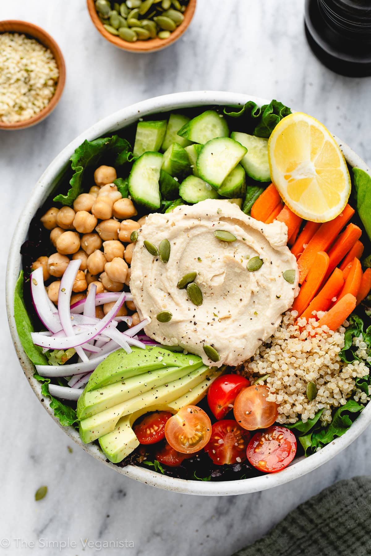 top down view of hummus bowl with items surrounding.