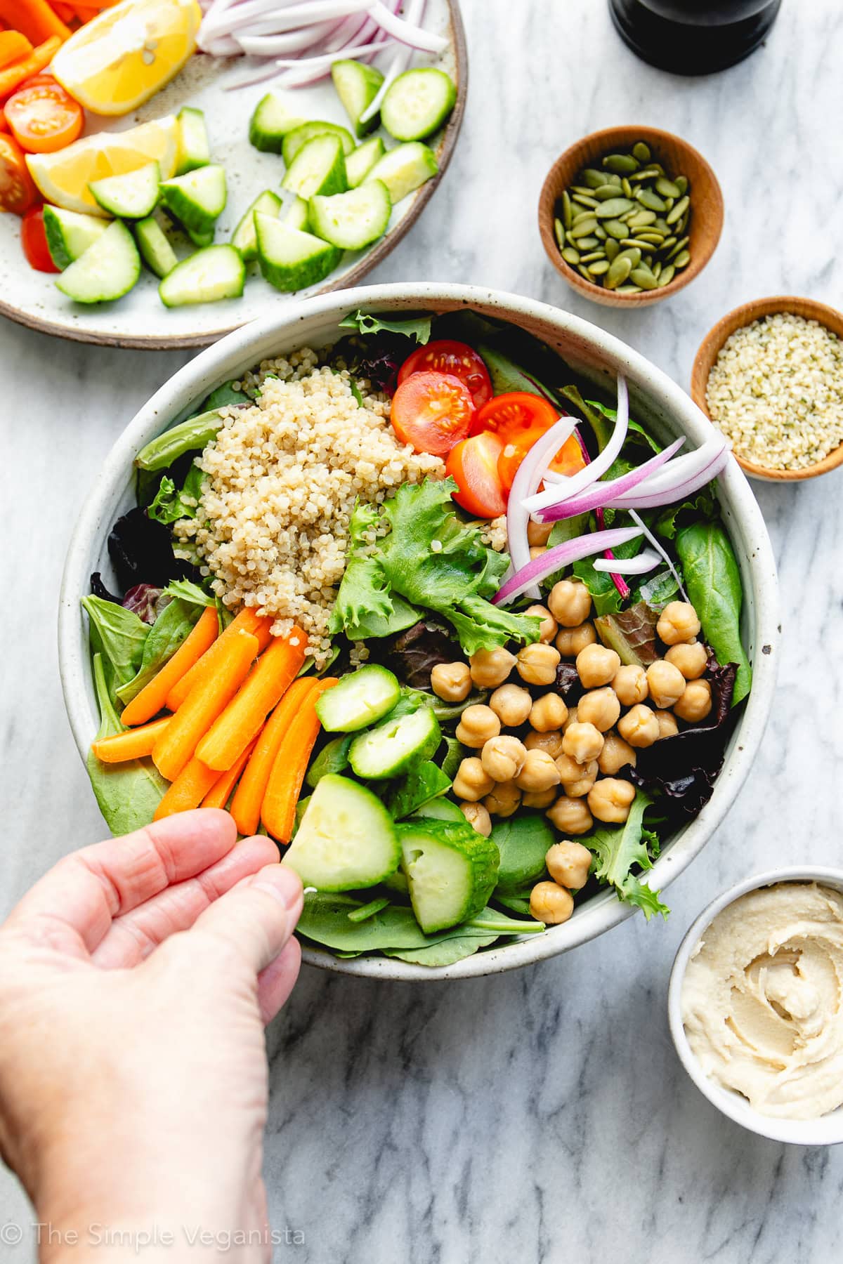top down view hummus salad bowl being assembled.