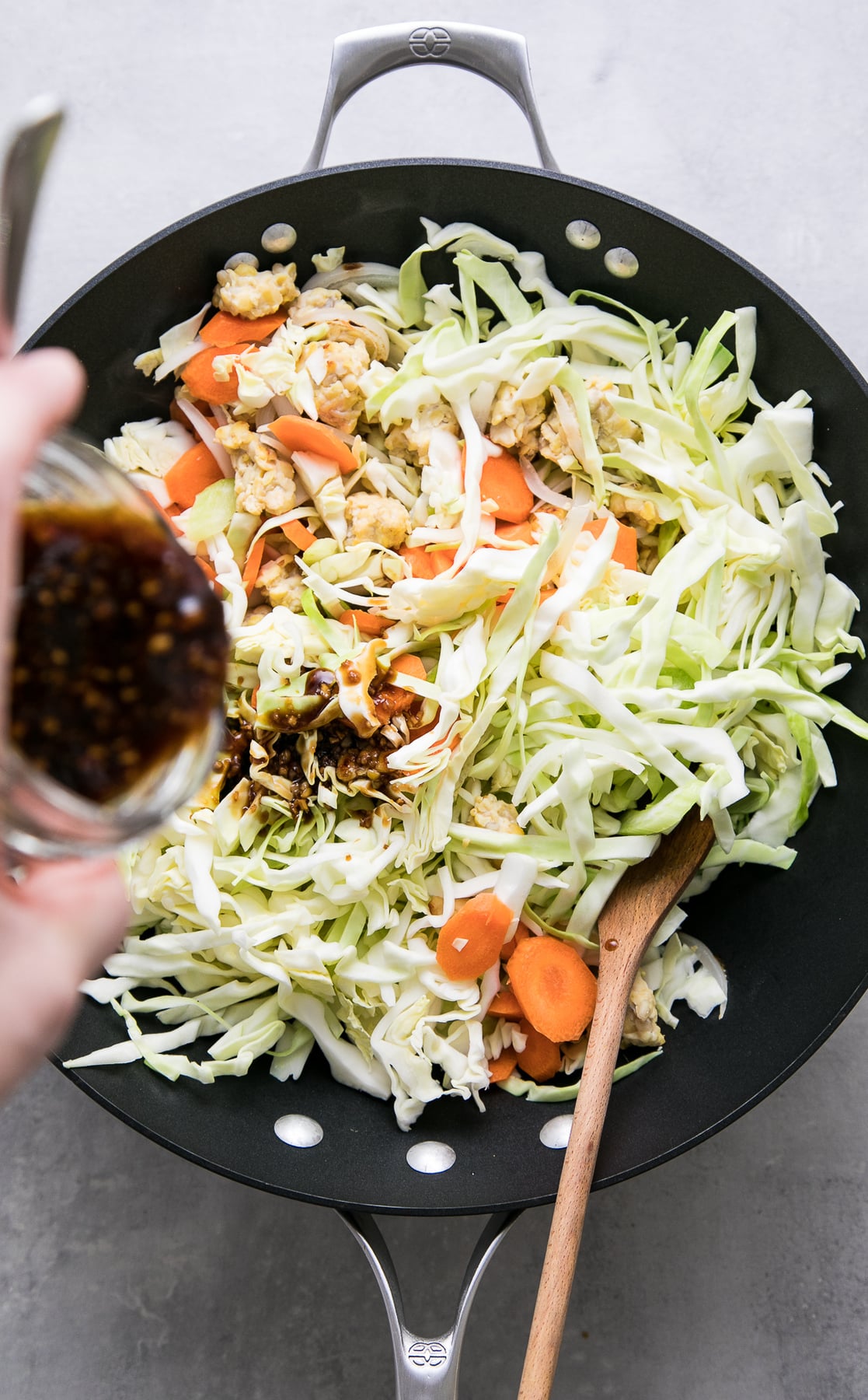 top down view of stir fry sauce added to veggies in wok.