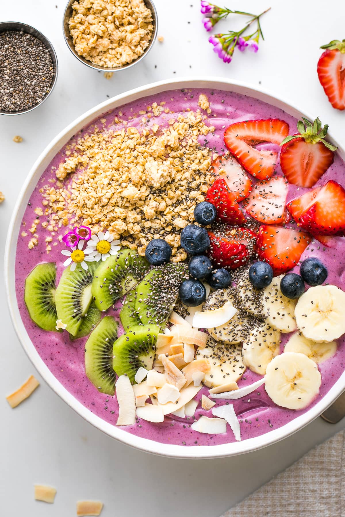 top down view of enlighten smoothie bowl topped with colorful fruit.