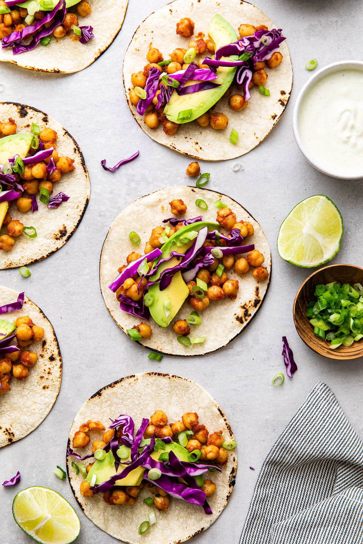 top down view of group of assembled chickpea tacos with items surrounding.