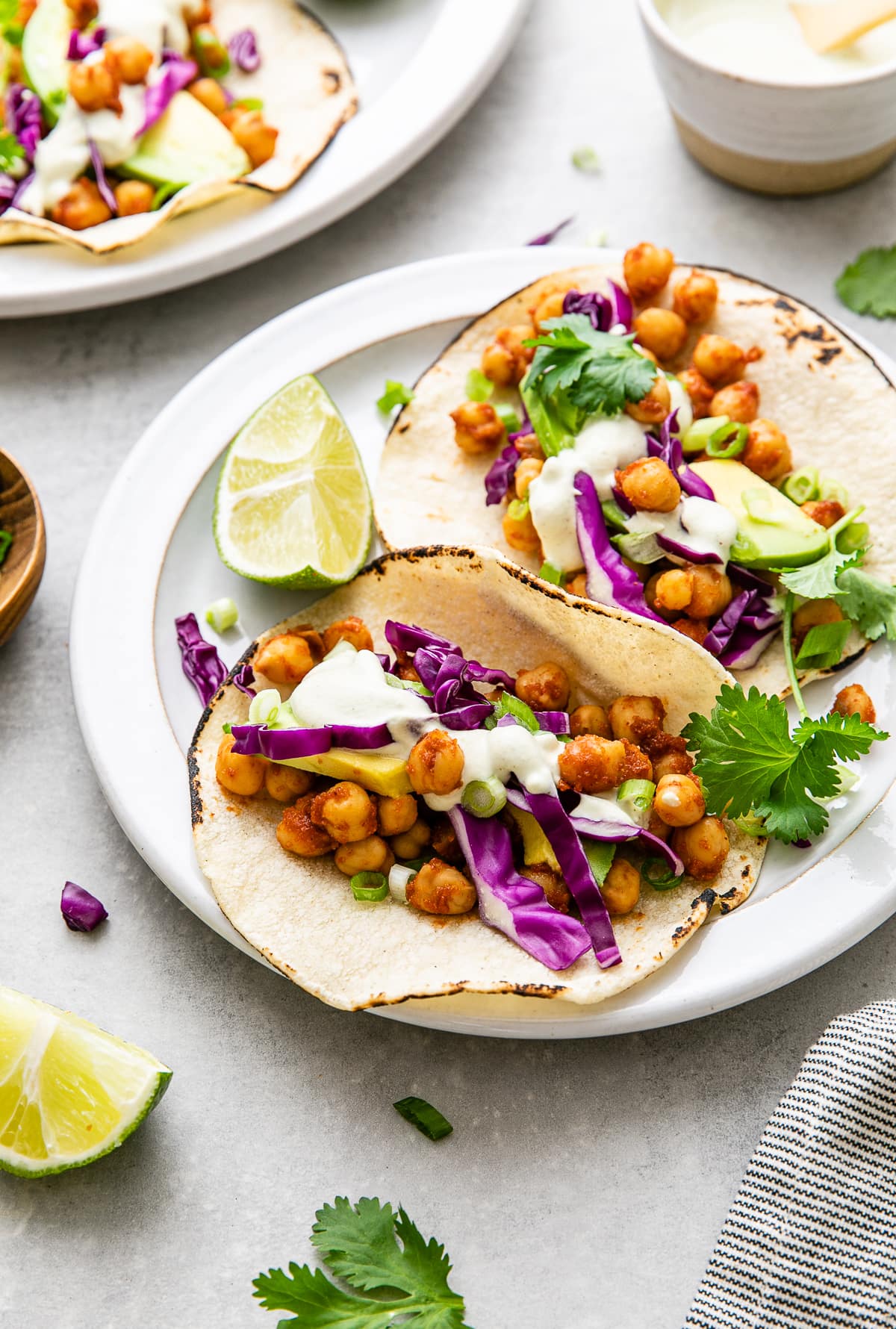 side angle view of plate with chickpea tacos and items surrounding.
