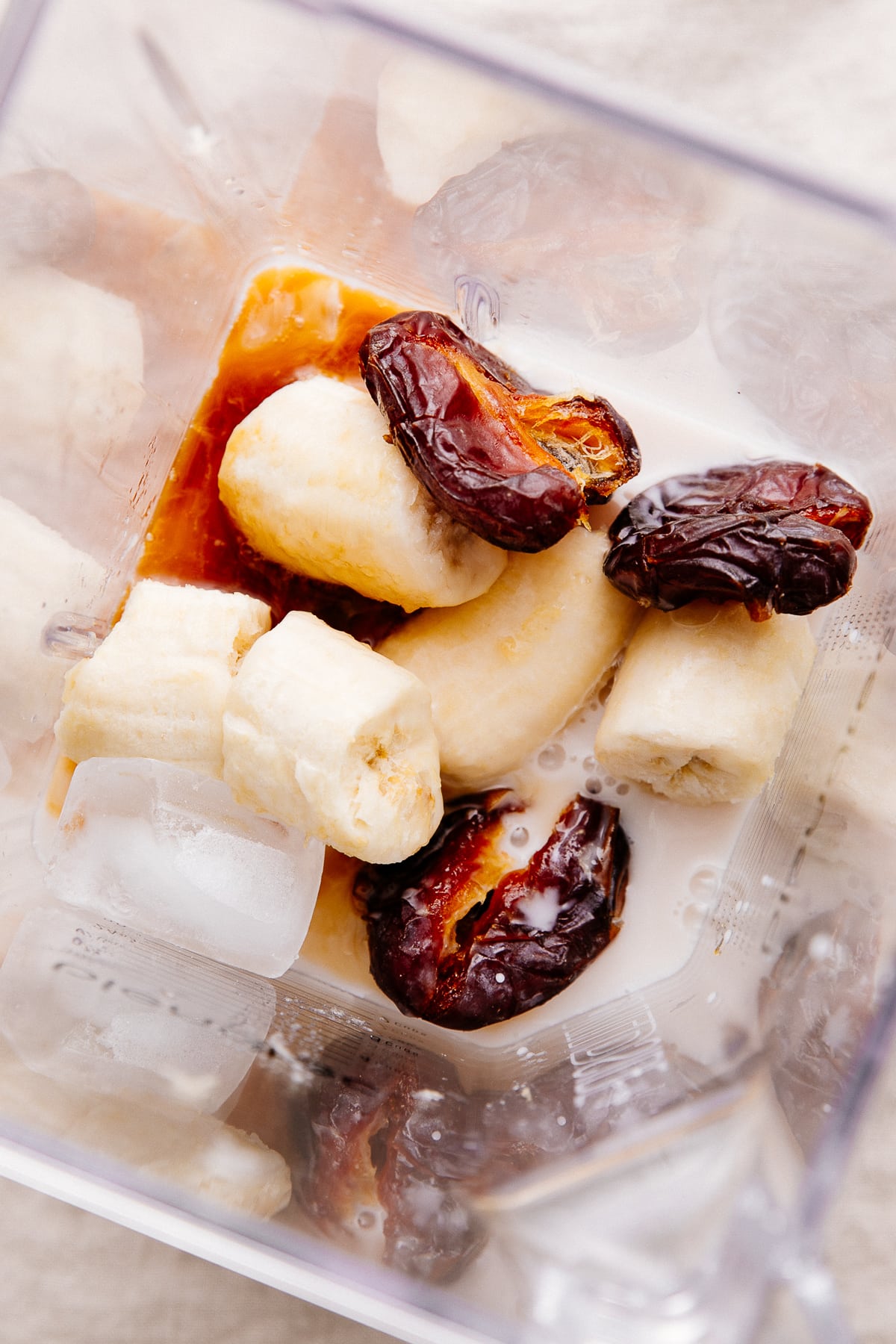 top down view of date smoothie ingredients in a blender cup.