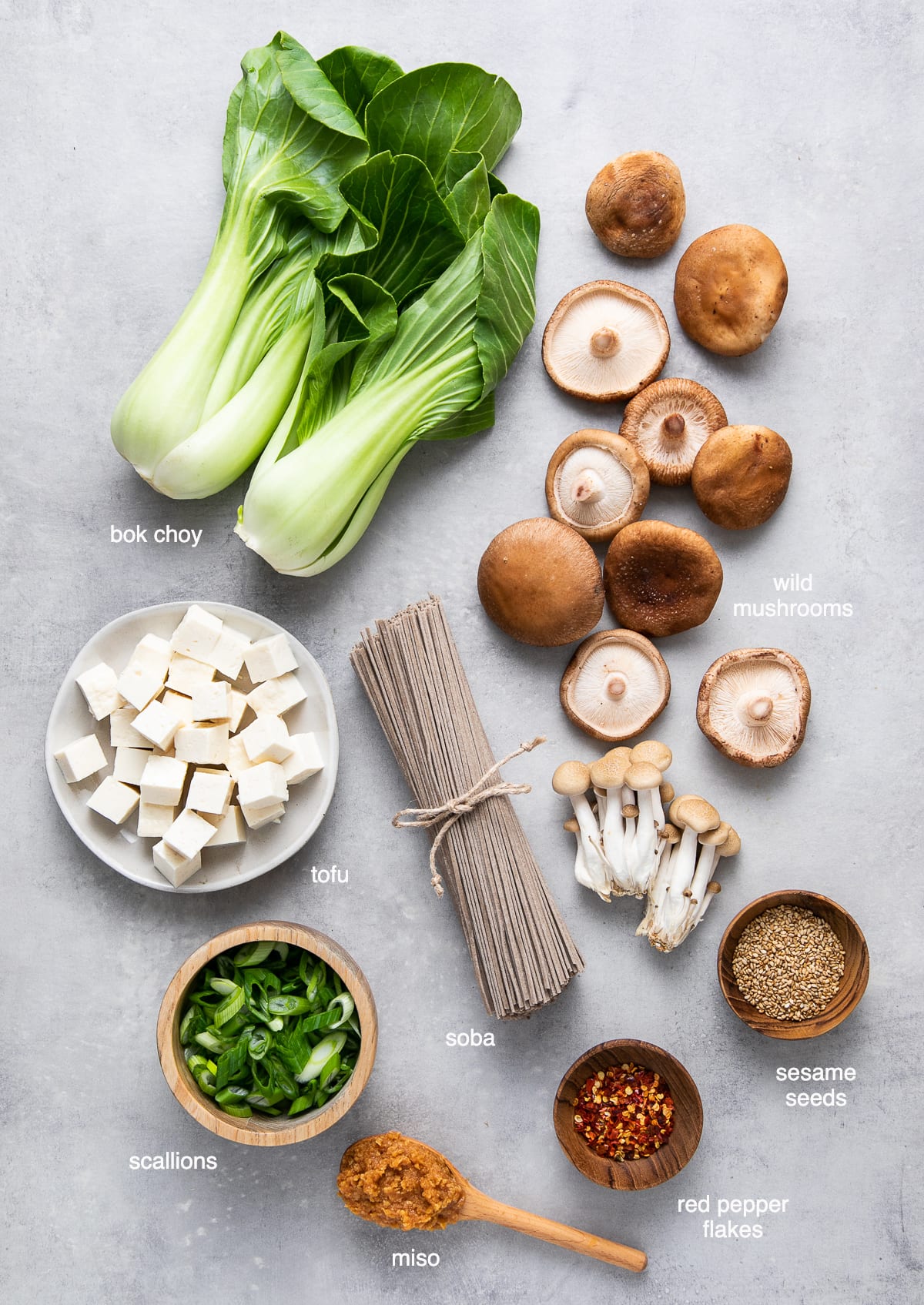 top down view of ingredients needed to make bok choy mushroom miso soba noodle soup