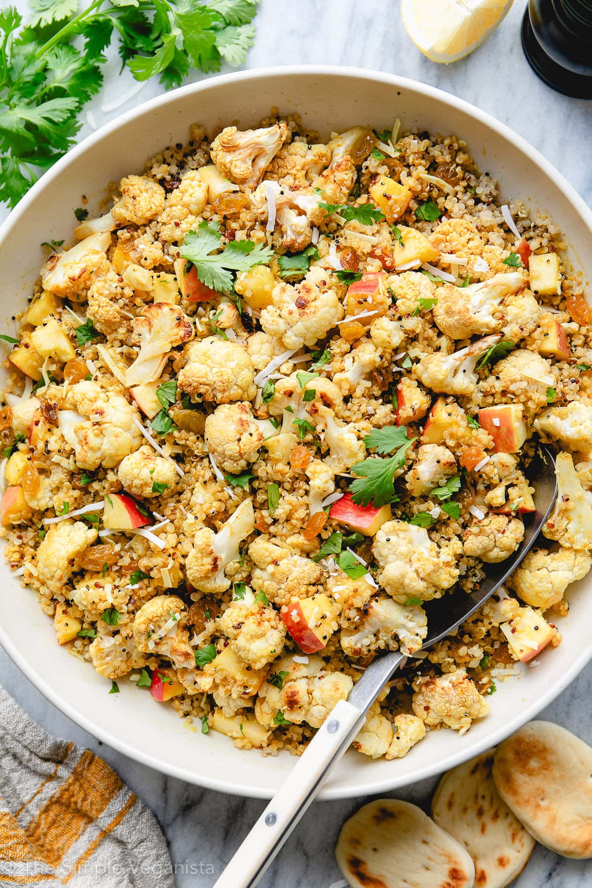 top down view of serving bowl with curried cauliflower quinoa salad with apples, raisins, and sweet, tangy dressing.