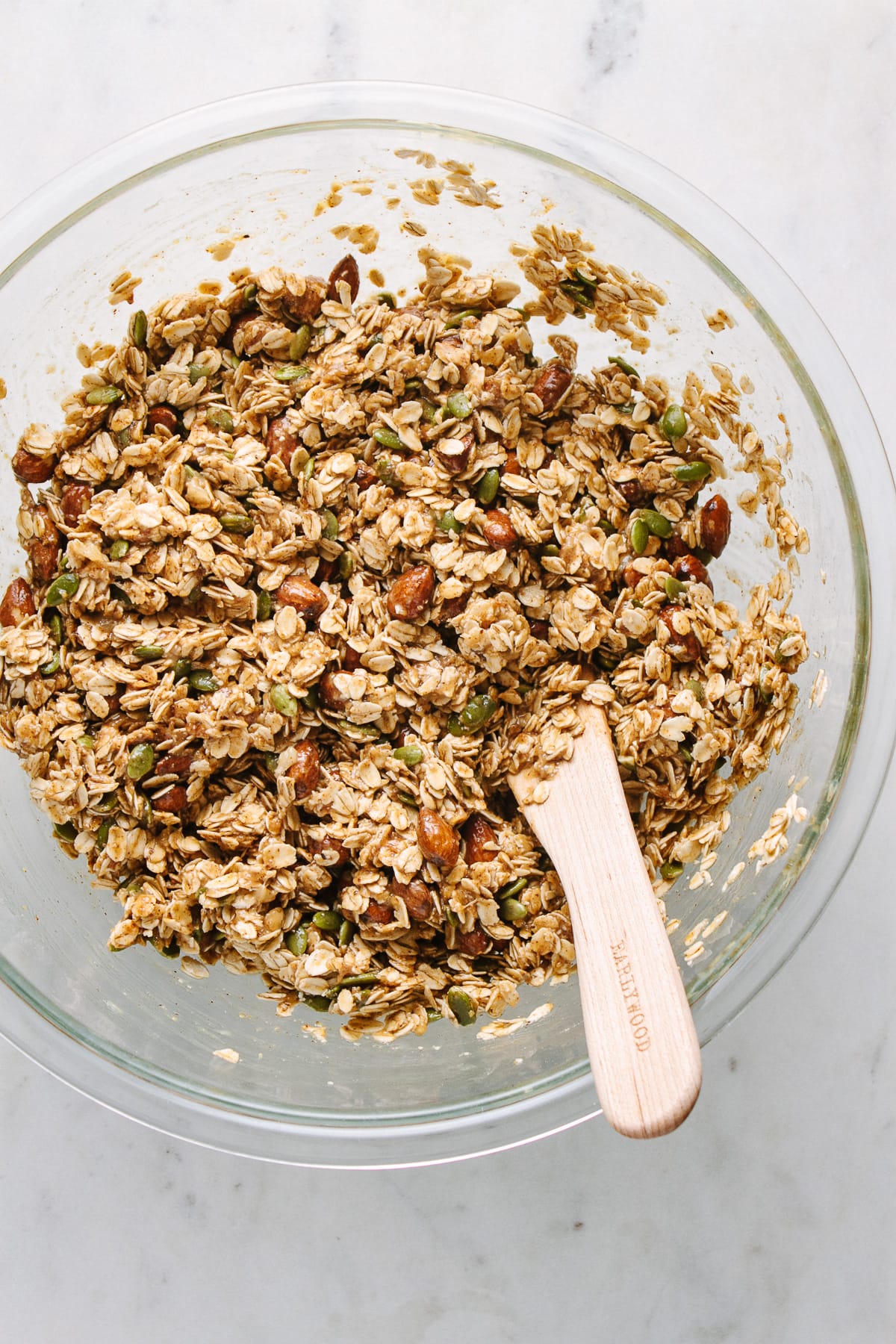 top down view of all ingredients to make peanut butter banana granola snack clusters mixed in a bowl.