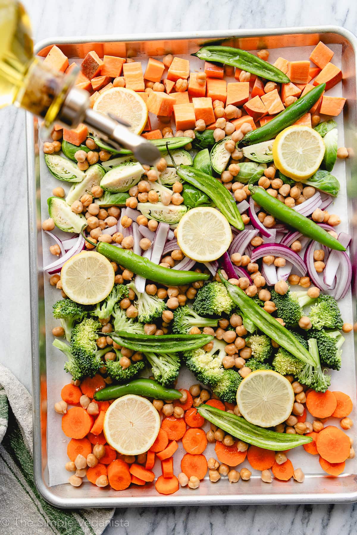 top down view of prepping veggies with oil before roasting.