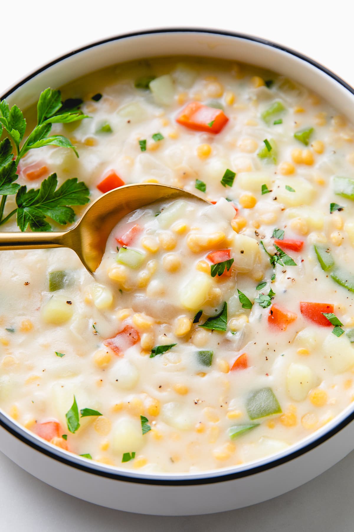 side angle view of spoonful of chana dal chowder with sweet potatoes.