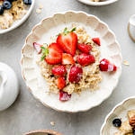 top down view of bowl of healthy oatmeal with strawberries and cream.