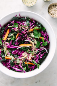 top down view of a mixing bowl with ingredients to make kale red cabbage slaw recipe.