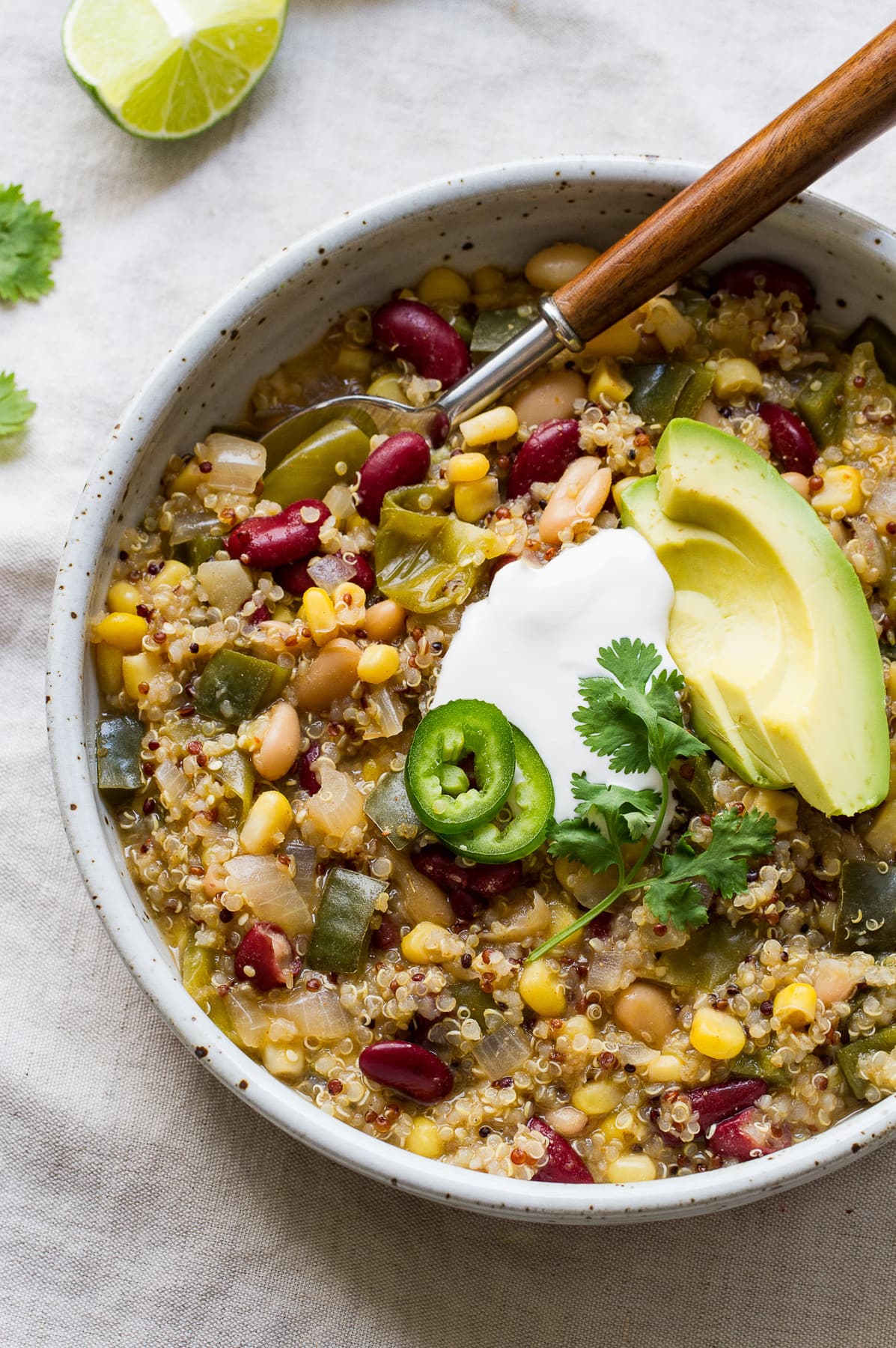 top down view of quinoa chili verde in a bowl with spoon.