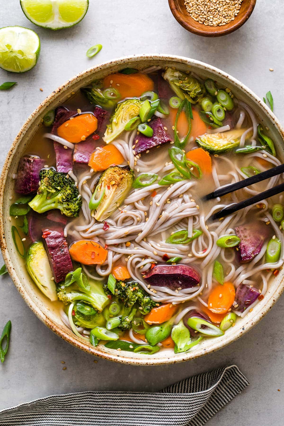 top down view of bowl with serving of soba miso soup with vegetables and items surrounding.