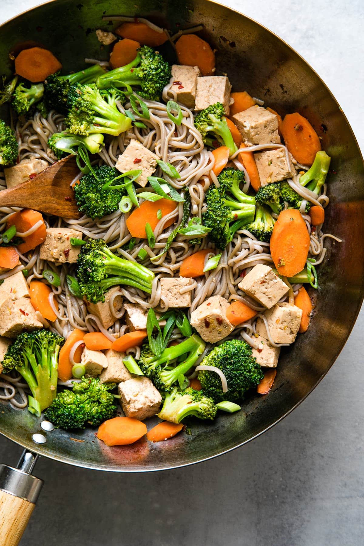 top down view of wok with freshly made soba noodle stir fry with tofu, broccoli and carrots.