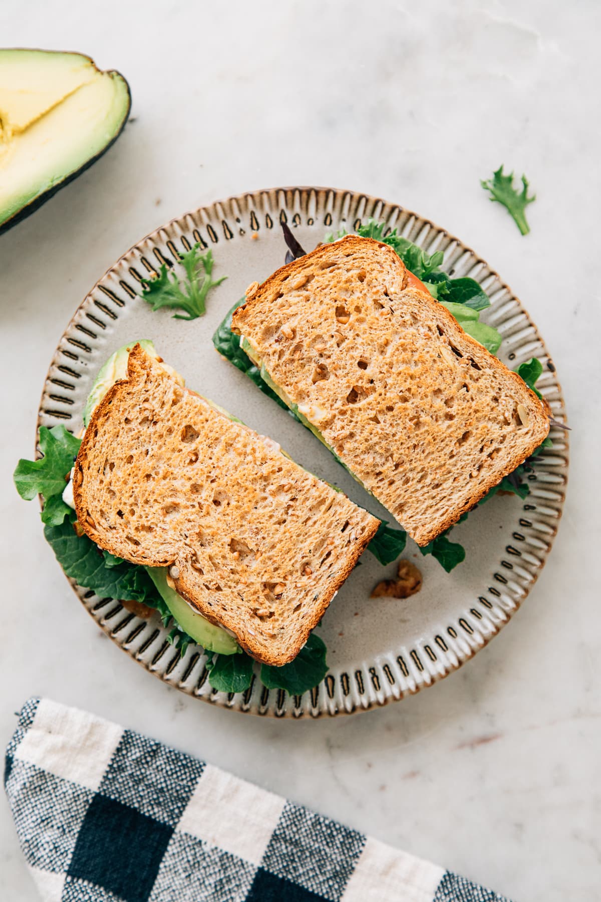 top down view of sandwich sliced in half on small plate.