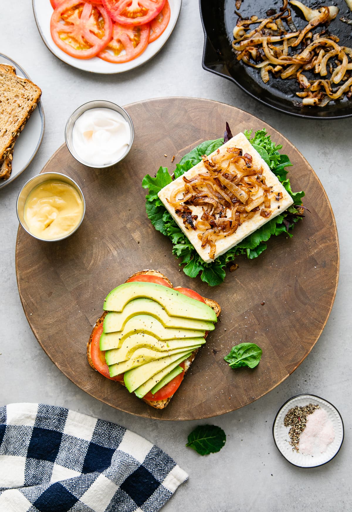 top down view showing the process of building a tofu avocado sandwich.