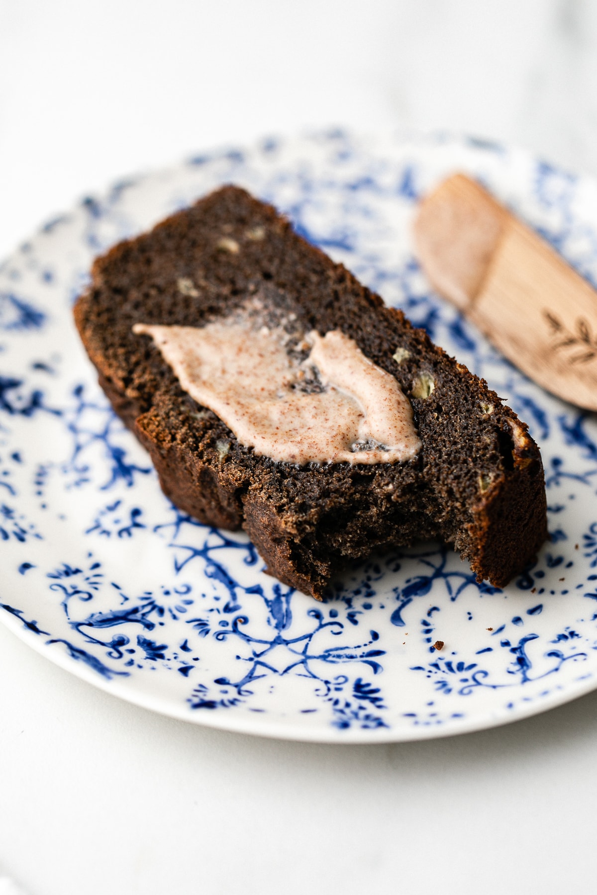 side angle view of buckwheat banana bread on a plate and topped with almond butter.