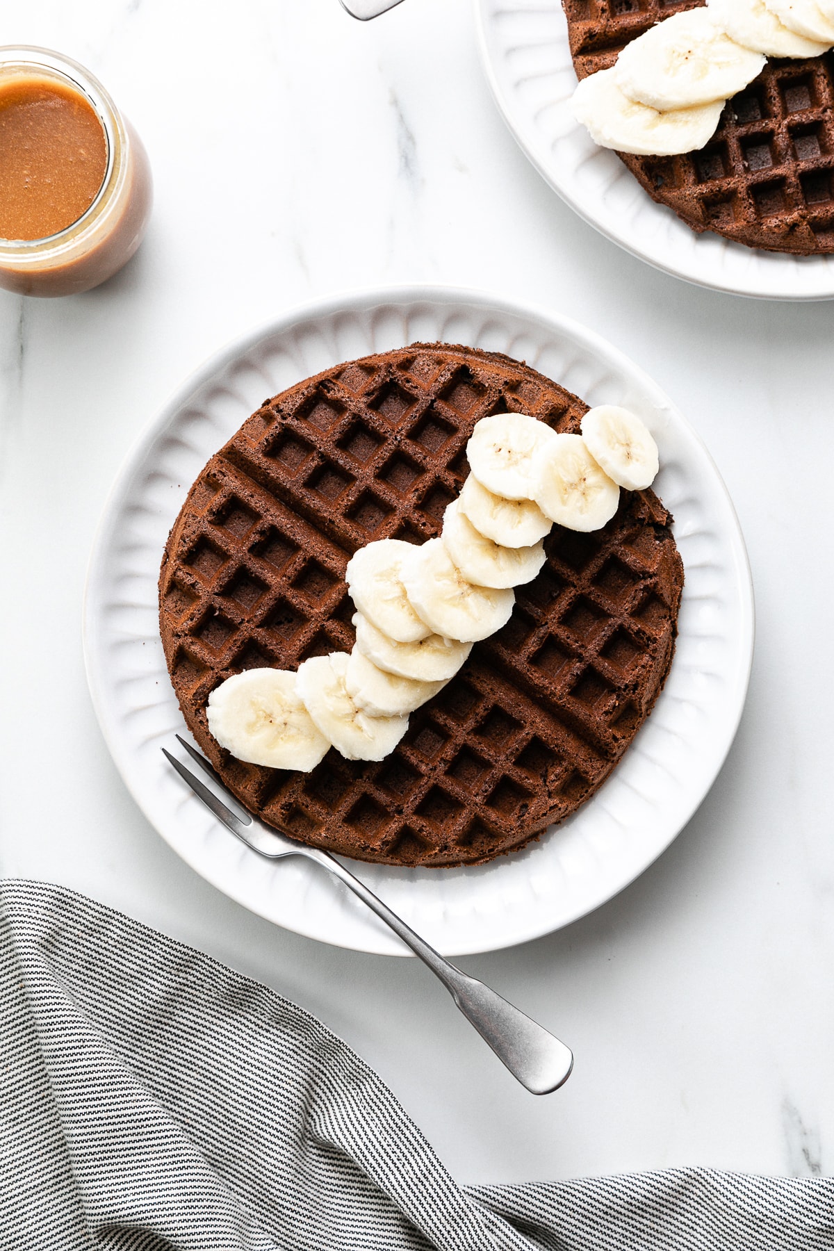 top down view of chocolate buckwheat waffle with items surrounding.