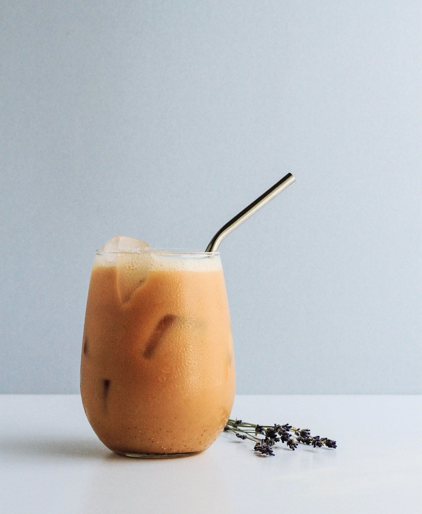 head on view of lavender chai tea in a glass with straw.