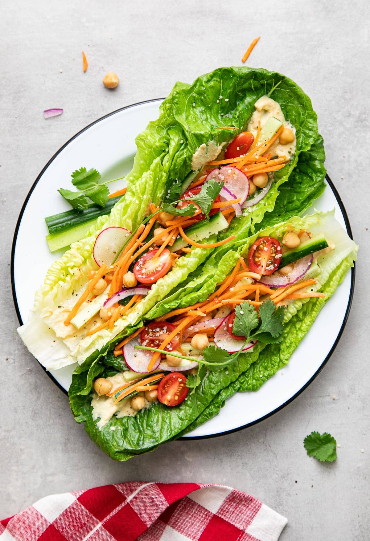 top down view of light and healthy, fresh vegan lettuce wraps on a plate with items surrounding.