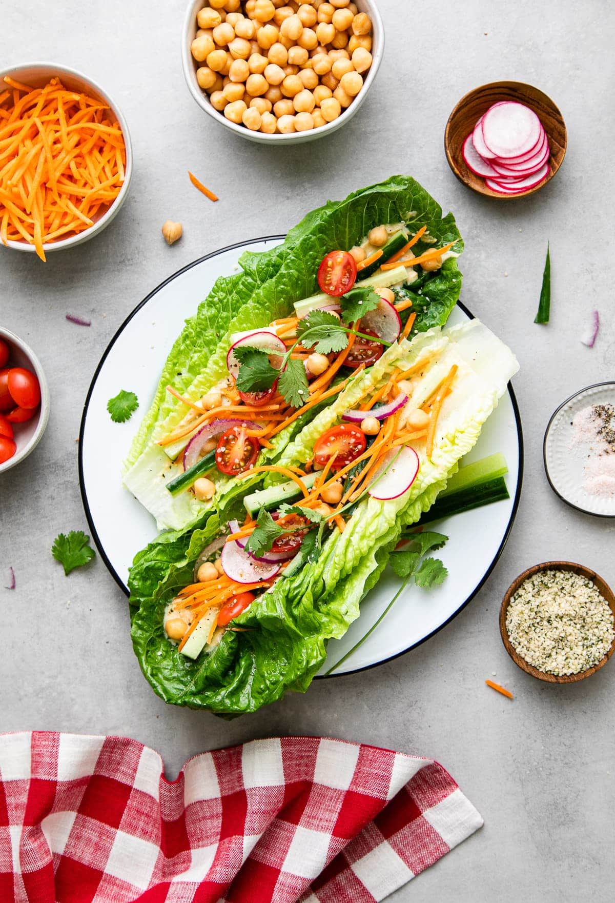 top down view of light and healthy, fresh vegan lettuce wraps on a plate with items surrounding.