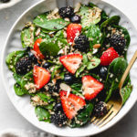 top down view of healthy berry spinach quinoa salad in a bowl.