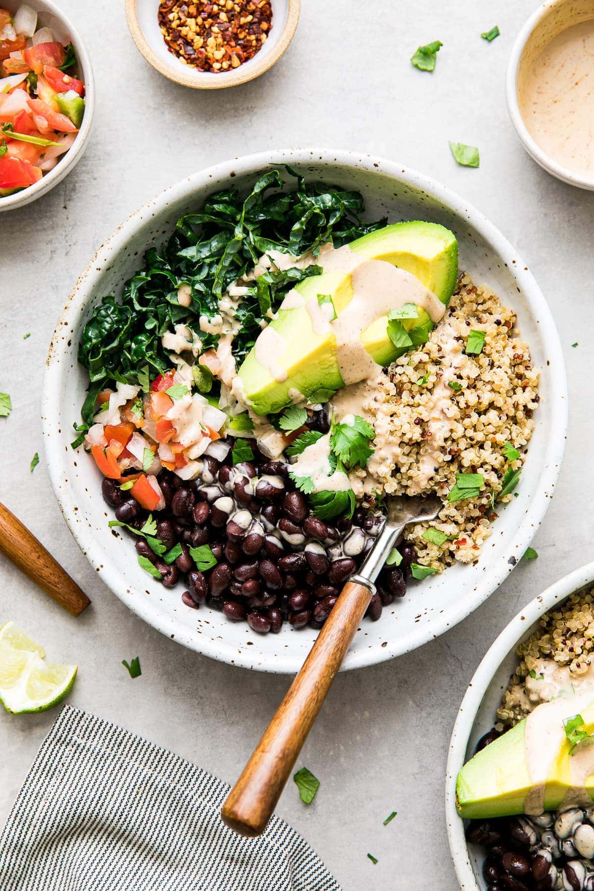 top down view of plated kale and black bean burrito bowl with fork.