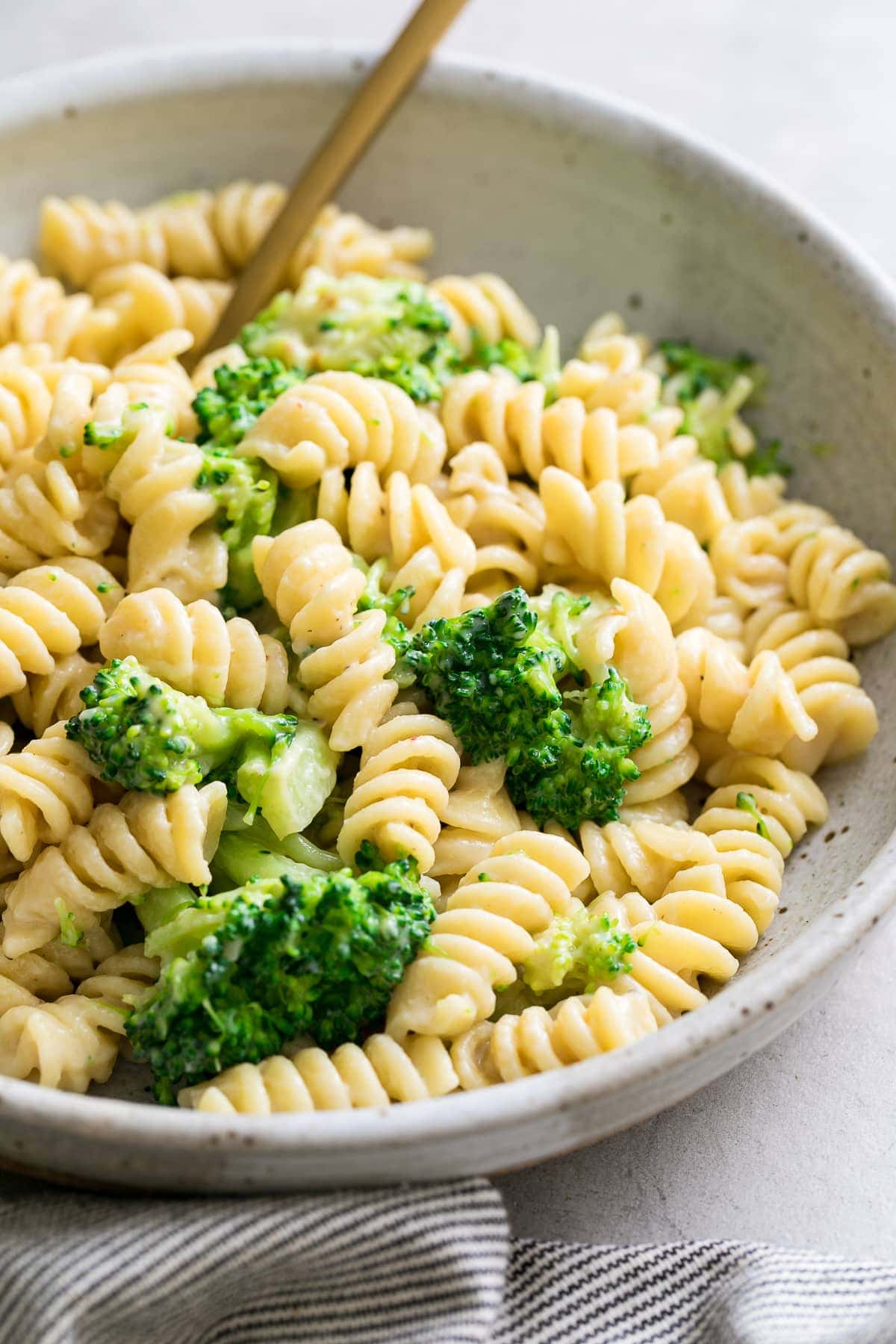 side angle view of creamy broccoli pasta in a bowl.