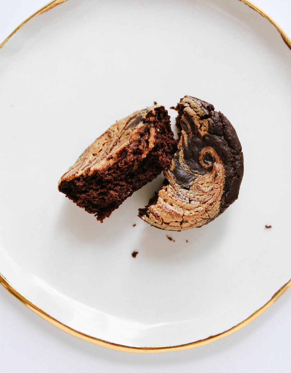 top down view of black bean brownie split in half on a white plate.