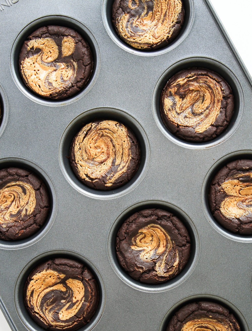 top down view of freshly made black bean brownies in a muffin tin.