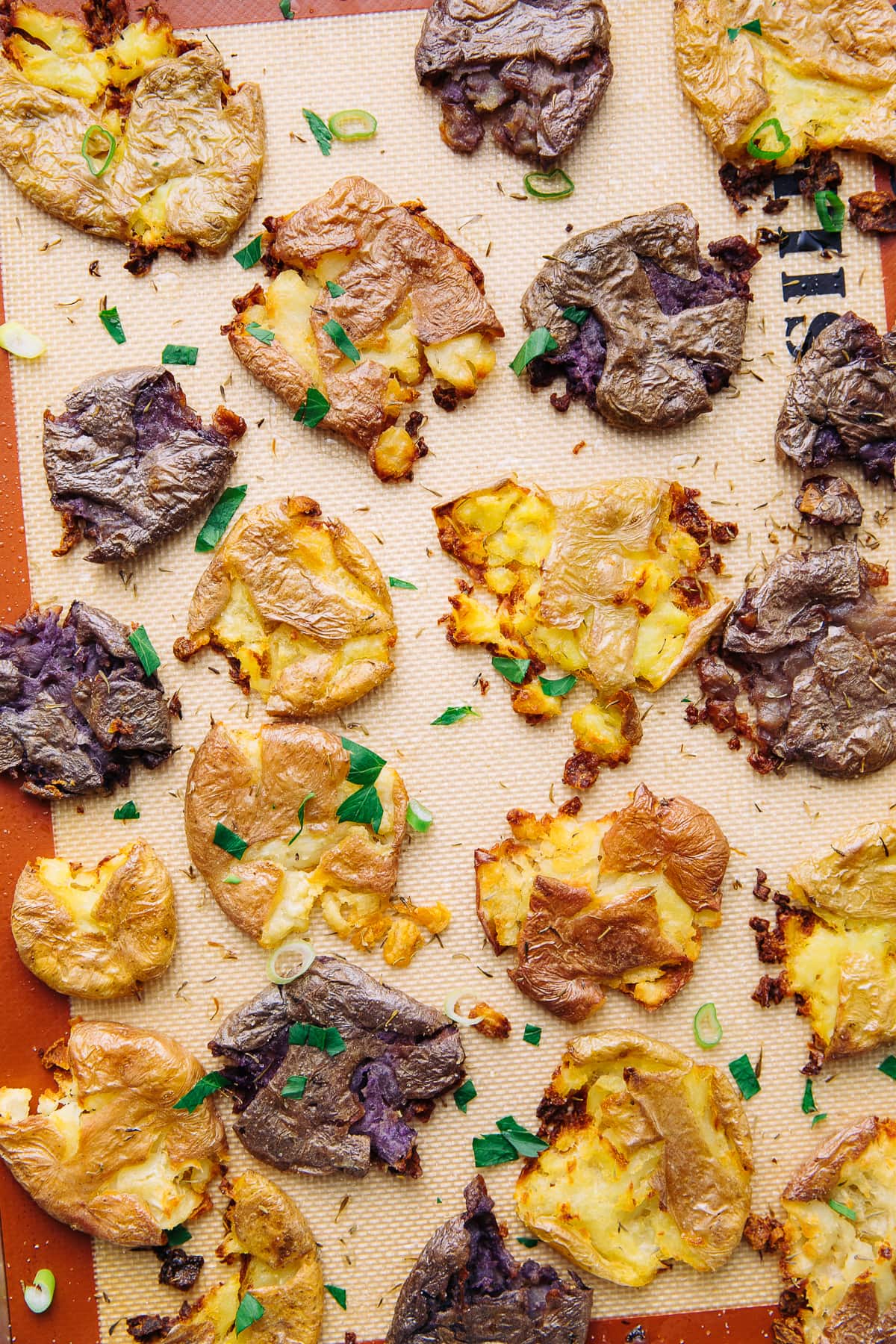 top down view of baking sheet with freshly baked crispy smashed potatoes.