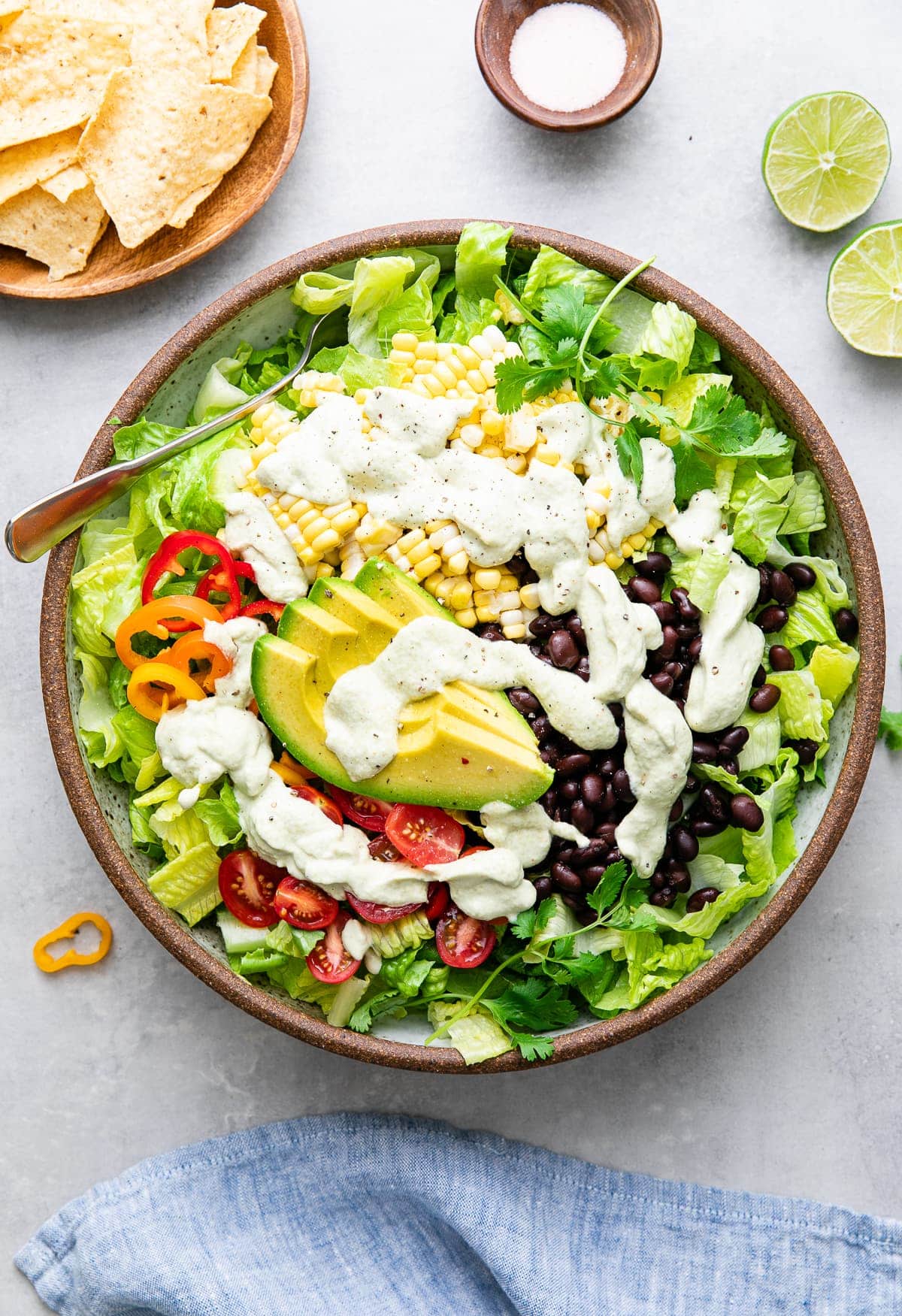 top down view of freshly made southwestern salad in a bowl with items surrounding.