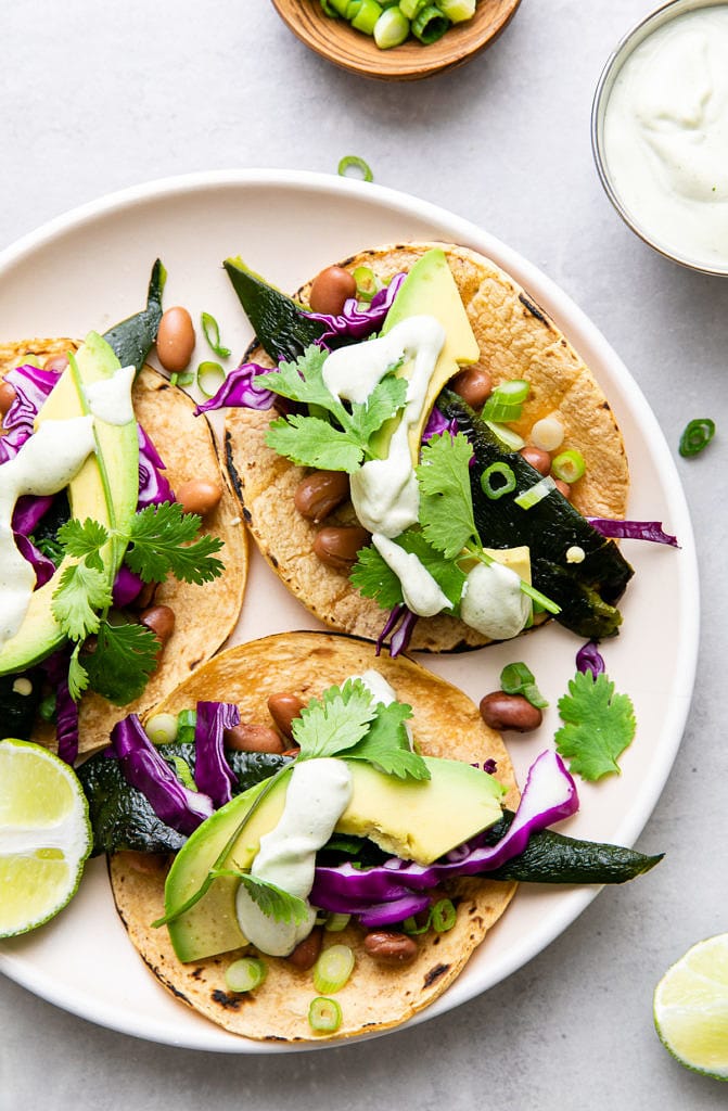 up close, top down view of poblano tacos with crema on a plate.