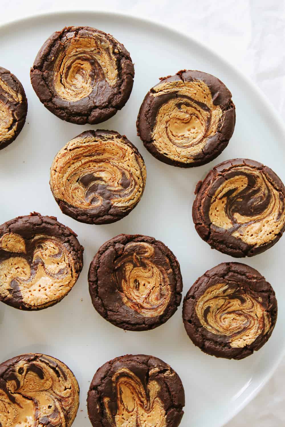 top down view of a group of gluten free black bean brownies on a white plate.