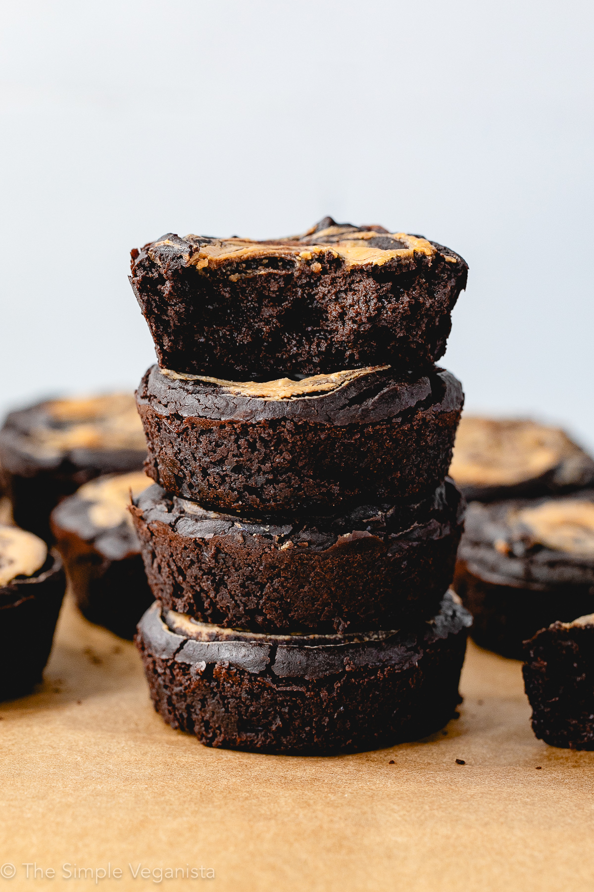 head on view of stacked fudgy vegan black bean brownies with a bite taken from the top one.