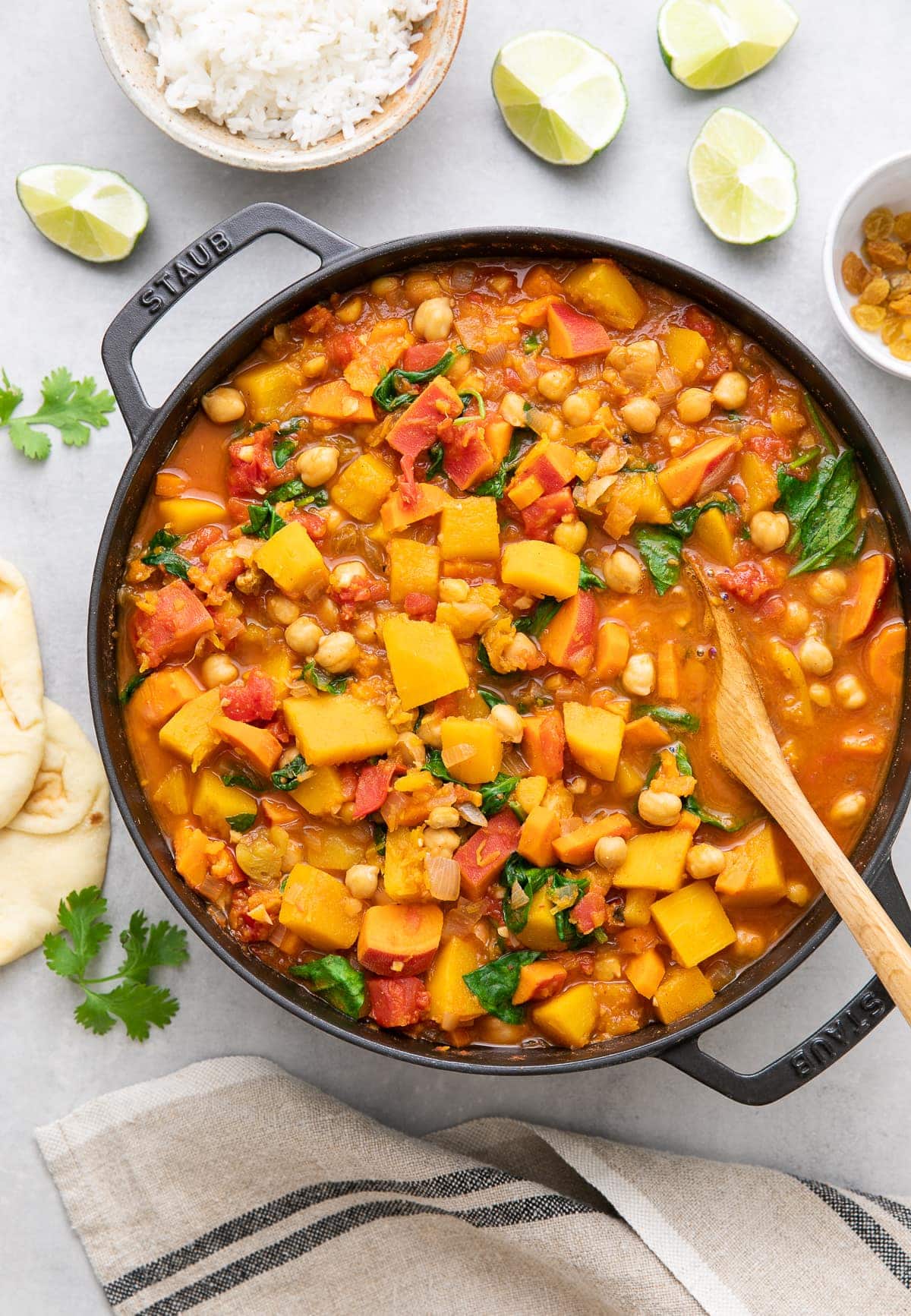 top down view of moroccan pumpkin and chickpea stew in a pot with items surrounding.
