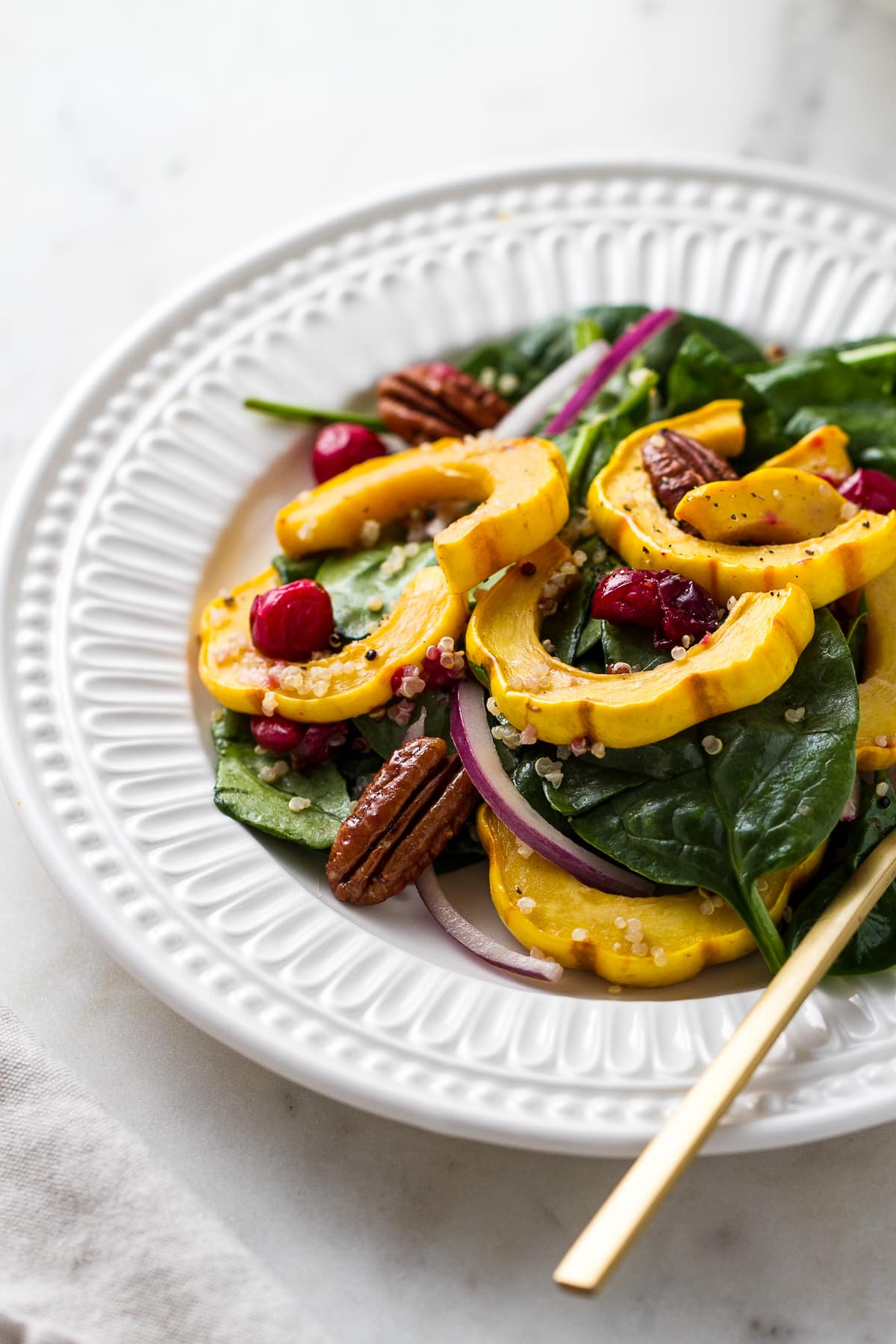 side angle view of roasted delicata squash salad recipe with cranberries and pecans.