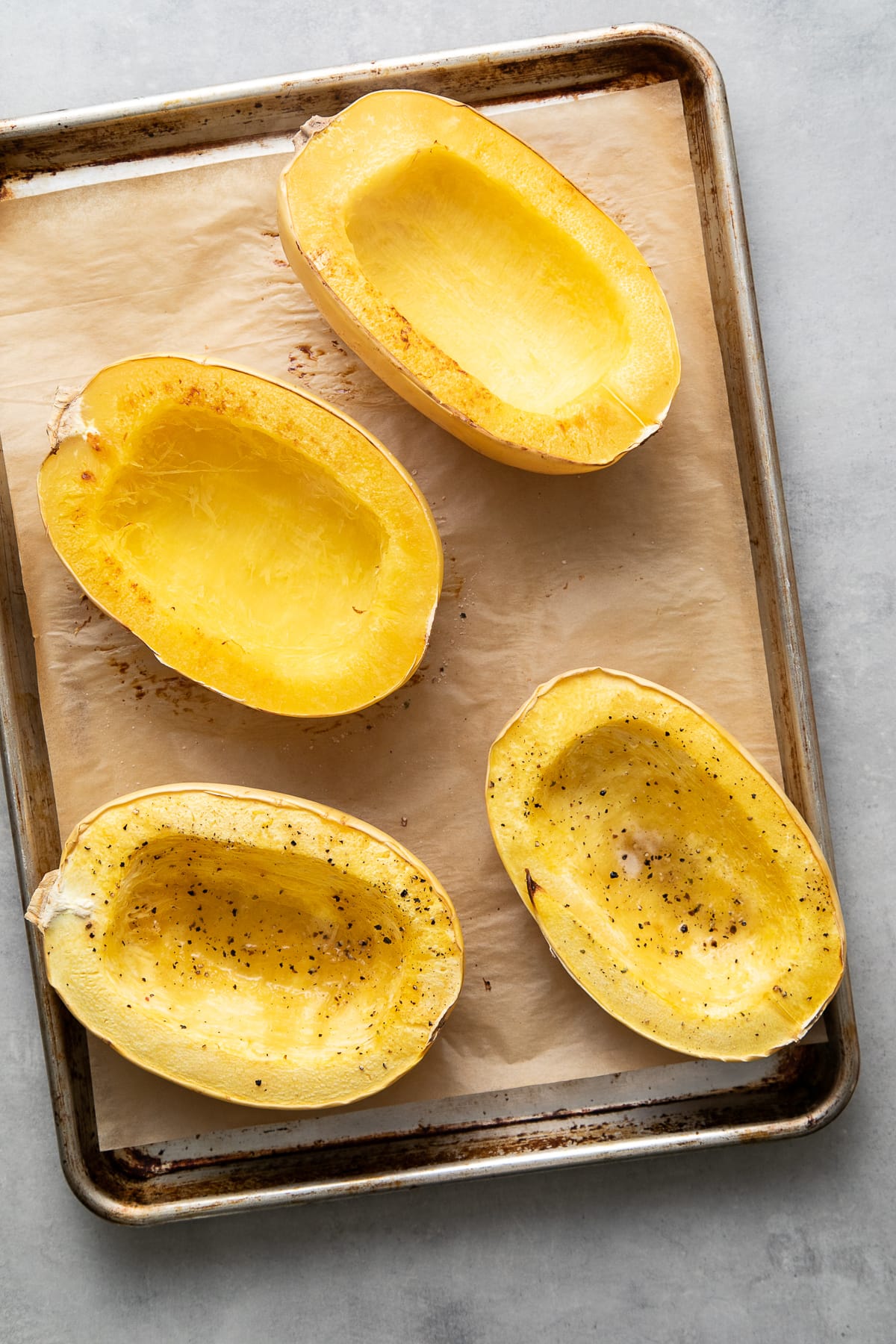 top down view showing freshly made spaghetti squash cooked 2 ways on a baking sheet.