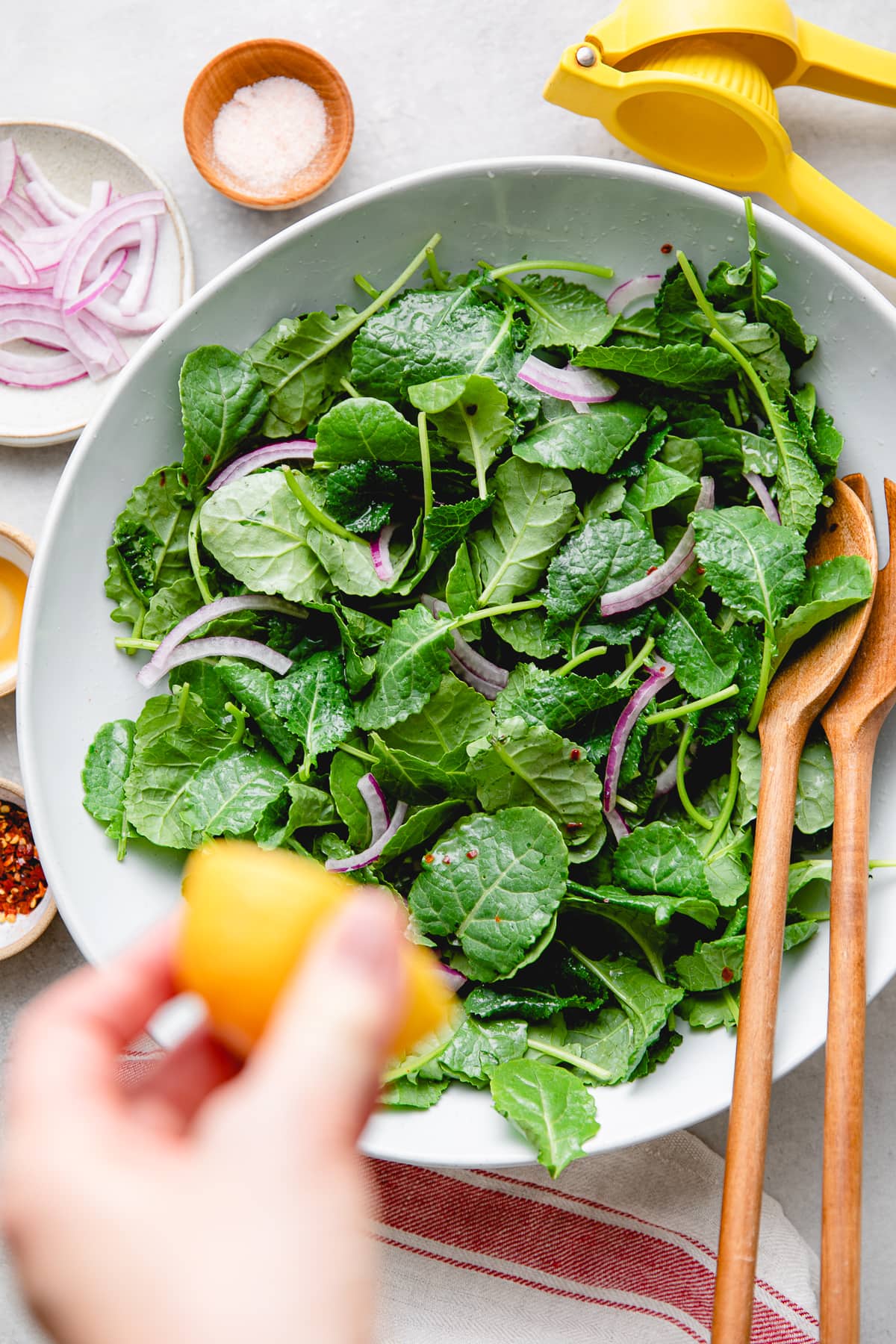 top down view of kale and onion in a bowl with lemon juice.