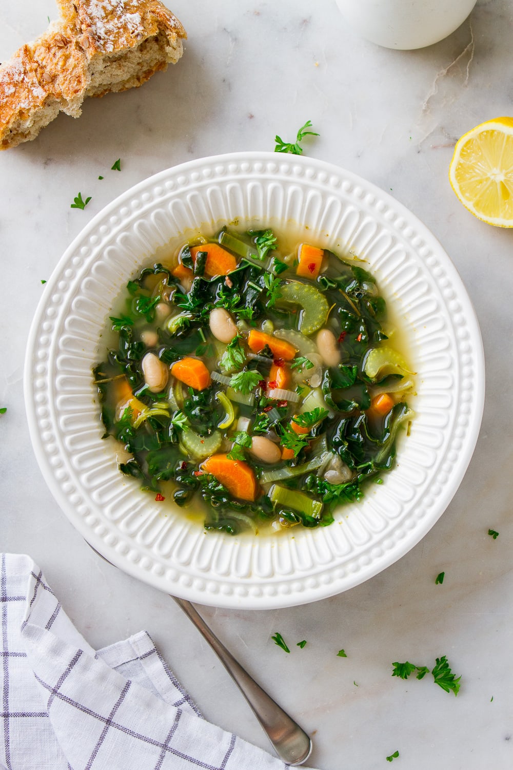 top down view of a bowl with a serving of healthy kale and white bean soup with leeks.