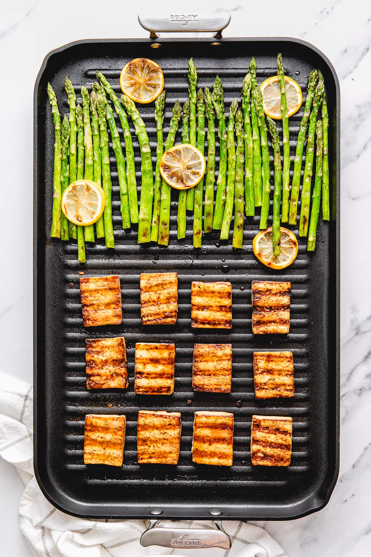 top down view of pan grilled tofu and asparagus on a nonstick grill.