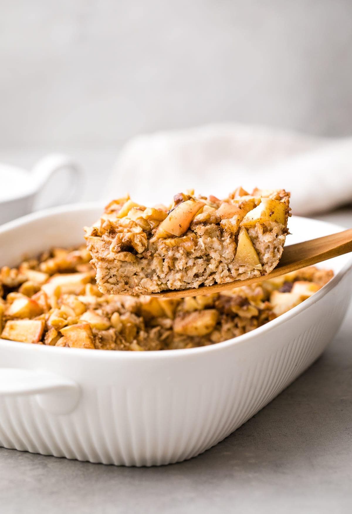 head on view of cinnamon apple baked oatmeal in a white dish.