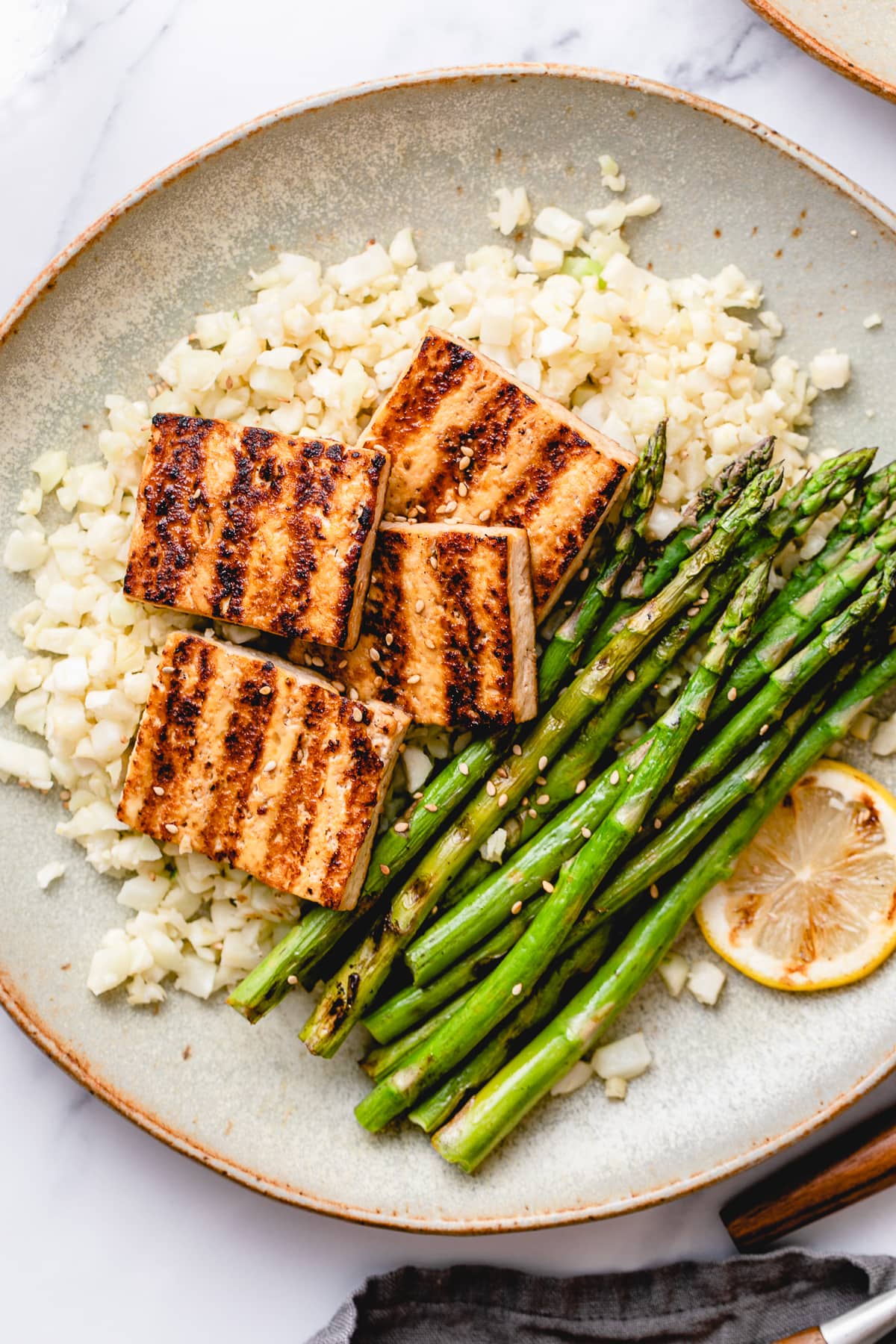 top down view of plated easy grilled tofu and asparagus with ginger cauliflower rice.