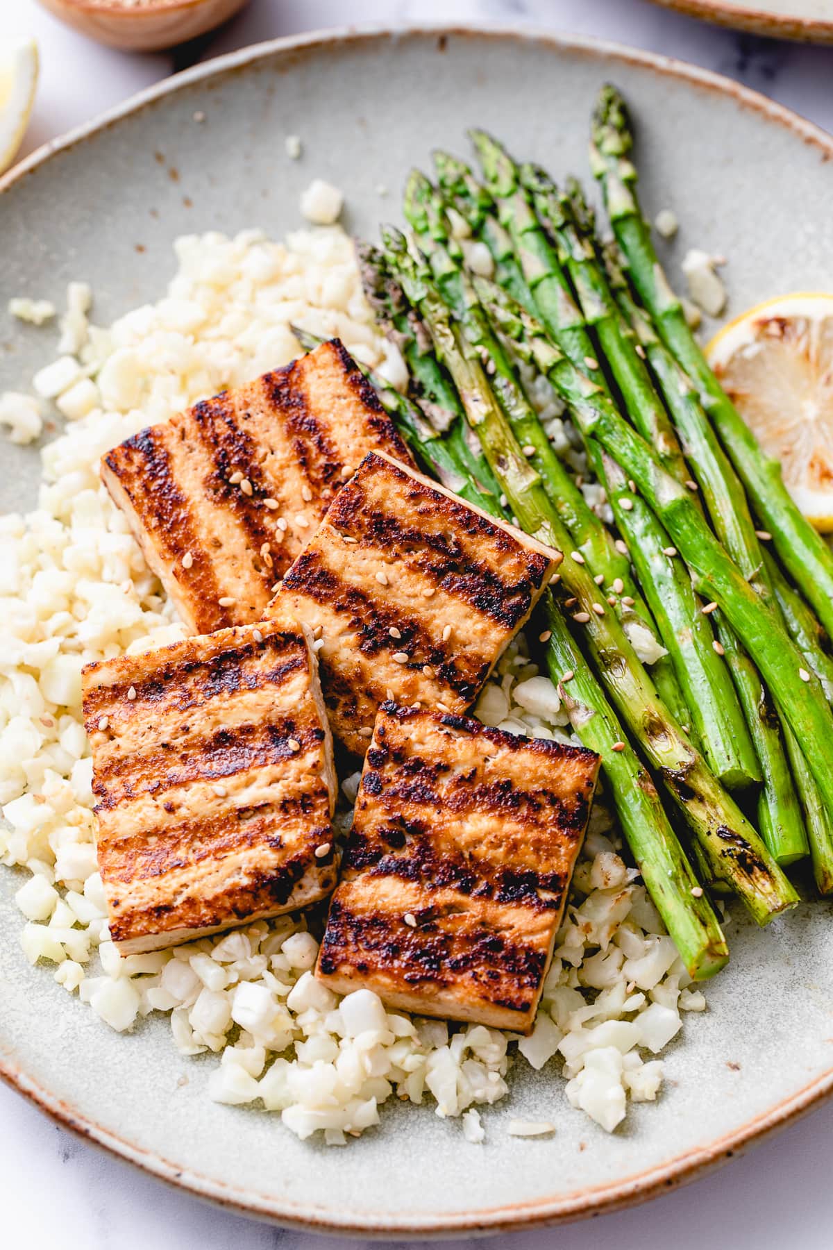 top down view of plated easy grilled tofu and asparagus with ginger cauliflower rice.