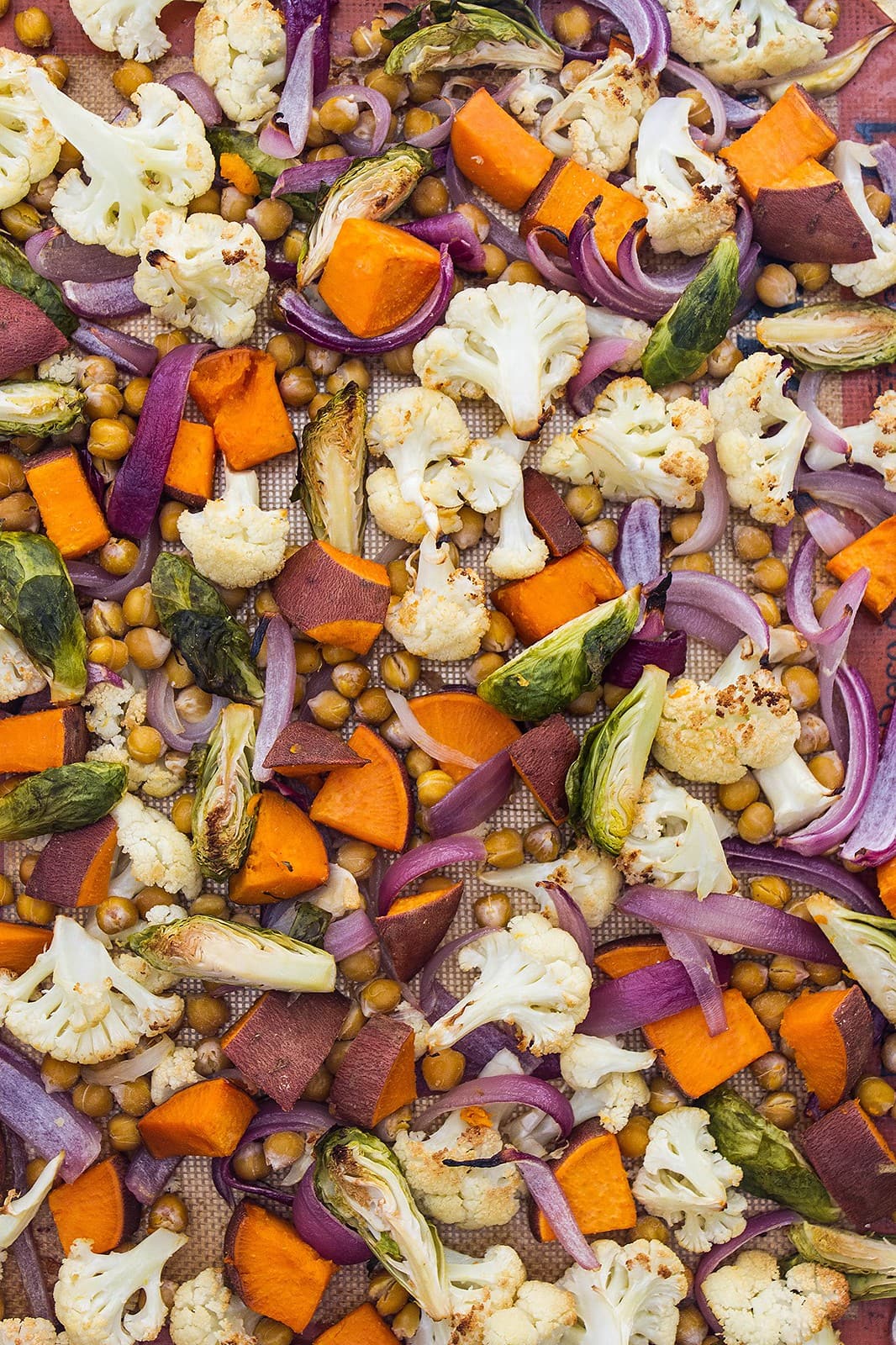 top down view of freshly roasted cauliflower, sweet potato and brussel sprouts.