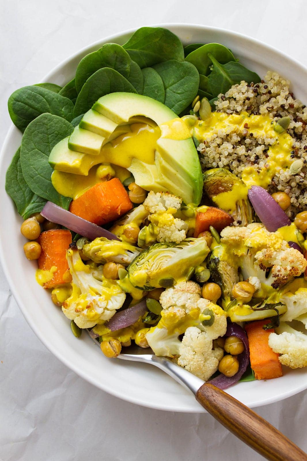 top down view of a bowl with a serving of roasted nourish bowl with turmeric tahini dressing.