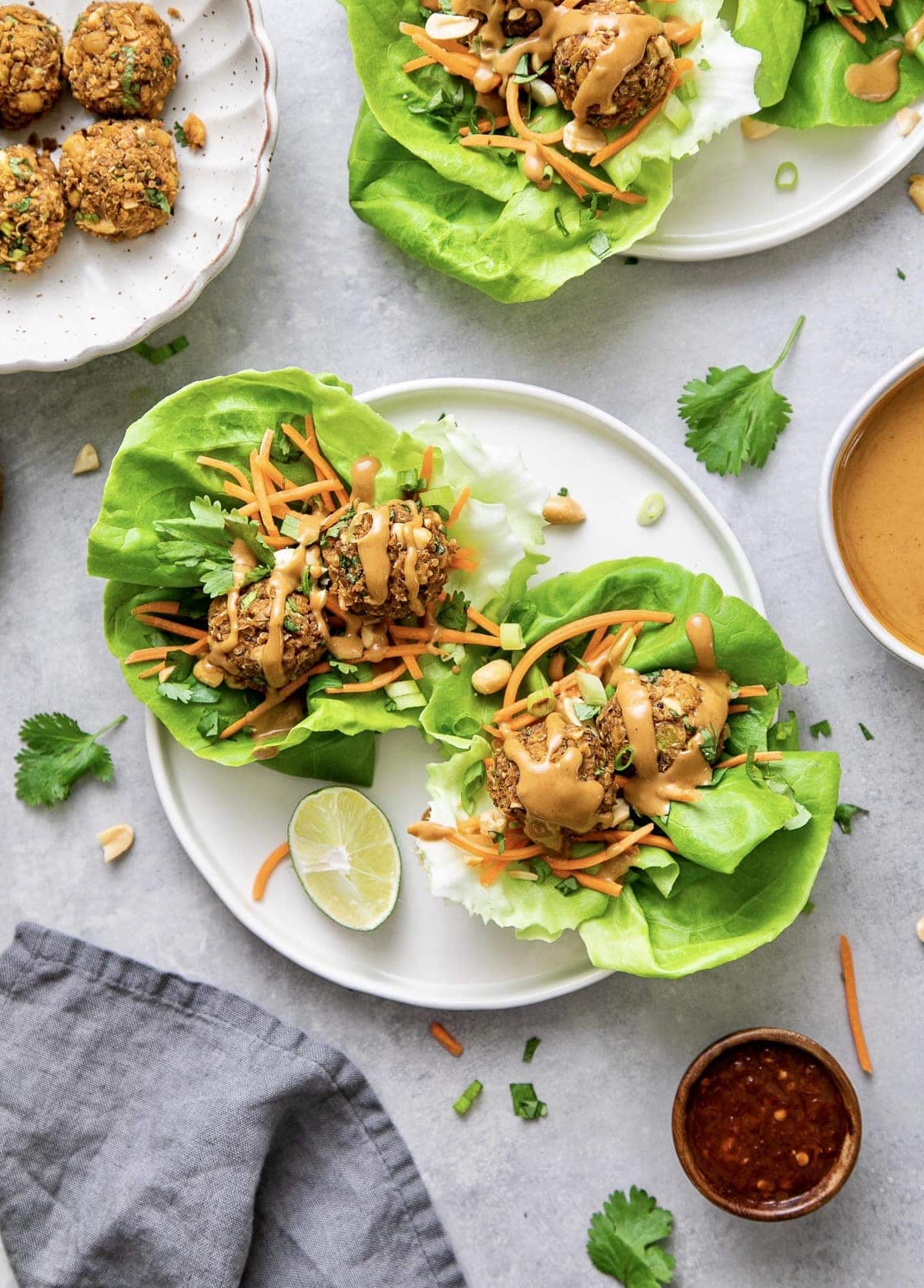 top down view of vegan lettuce wraps with thai quinoa meatballs on a plate with items surrounding.