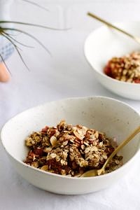 side angle view of a serving of easy strawberry rhubarb crisp in a bowl.