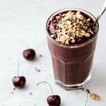 side angle view of a glass full of healthy chocolate cherry smoothie.