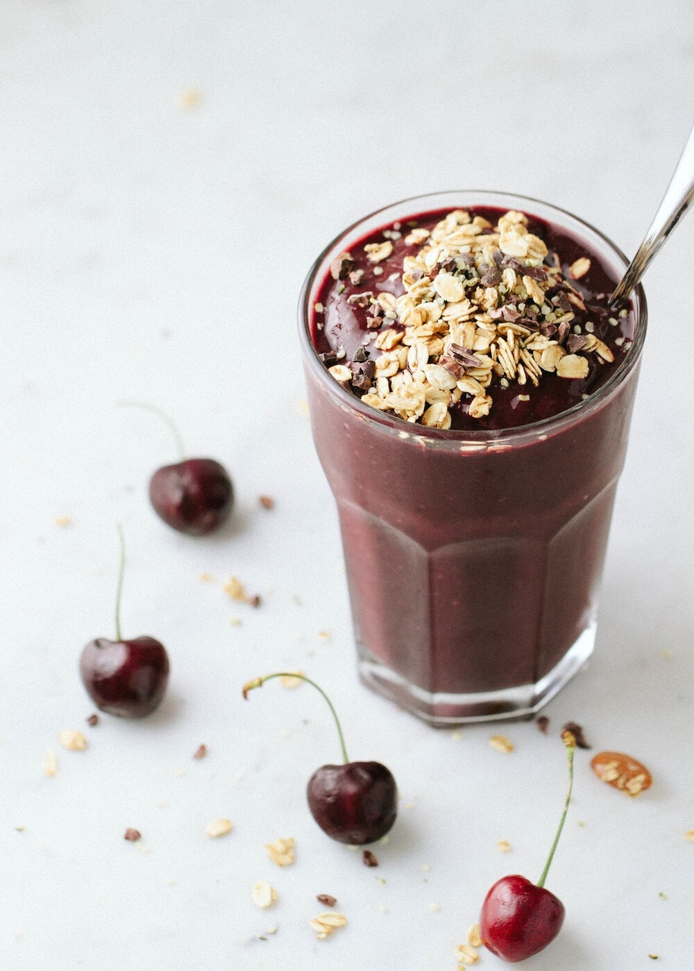 side angle view of a glass full of healthy chocolate cherry smoothie.