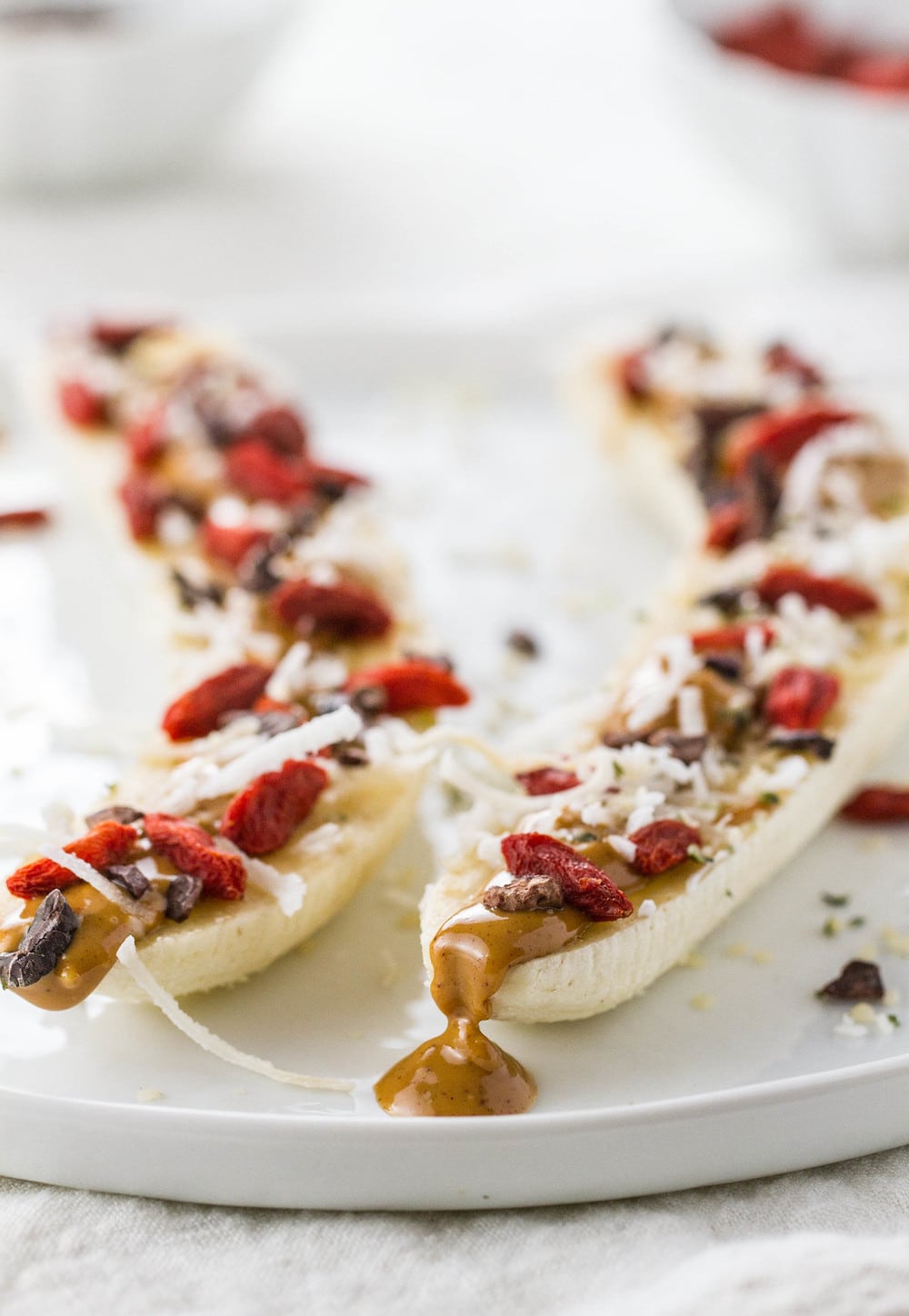 side angle view of loaded banana boats on a white plate.